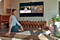 A woman does stretches while following along to a routine on her Samsung OLED TV
