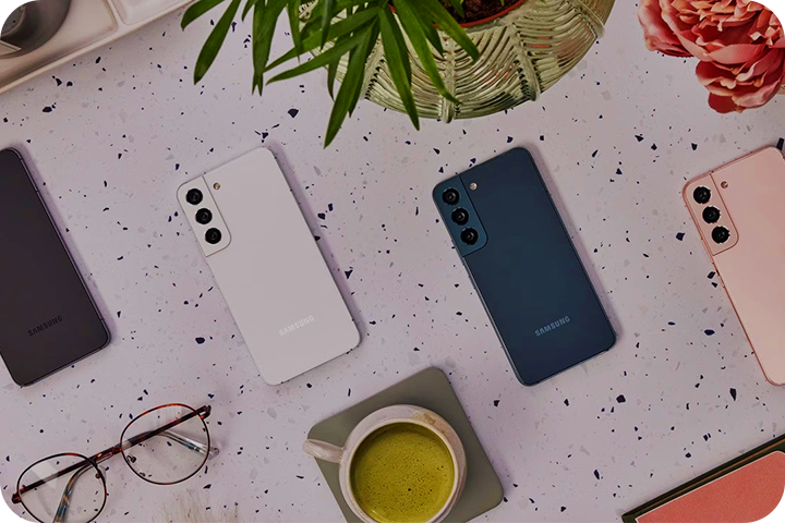 Four different colored Galaxy phones laid out from left to right: black, white, blue and pink