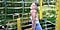 Millie Bobby Brown smiles with her eyes closed inside of her fenced-in garden.