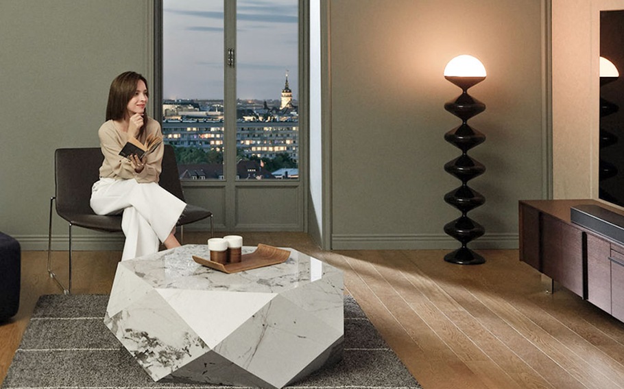 A woman reads a book in the living room.