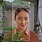 A woman in a garden looking at her plant, her face framed by the outline of a Note20.
