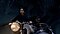 A smiling woman on a motorcycle and a man in the sidecar race through a forest at night.