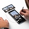 A top-side view of a man's hands interacting with a Galaxy S22 Ultra and S Pen on a white desk. The man (Caleb Natale) uses a black S Pen on the device screen. Illustrated dots lead to an enlarged inset image of the editing controls on the device.