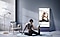 A woman stretches on a yoga mat in front of a Sero TV screen rotated into portrait mode.
