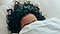 A woman lays in bed, her face partially covered by a blanket. An icon of a dolphin is in the bottom left corner.