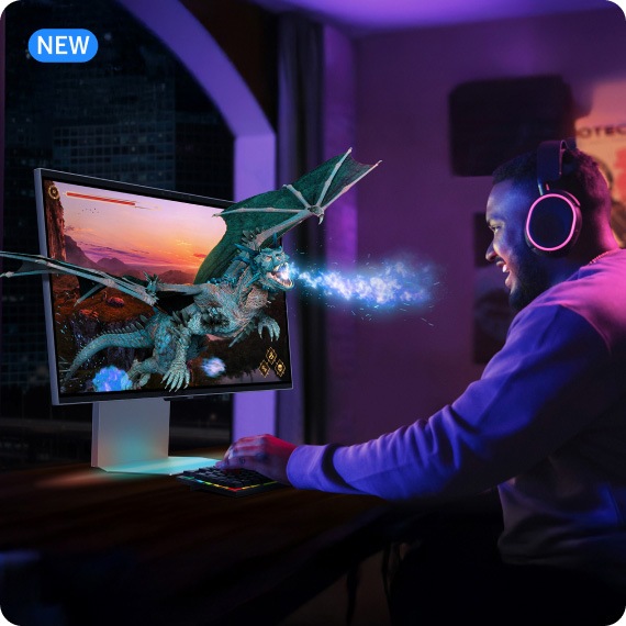 A lifestyle product shot of the Odyssey 3D gaming monitor, featuring a gamer wearing gaming headphones playing a game with a fire breathing dragon, which is coming to life out of the screen.