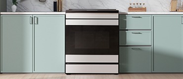 Induction range in kitchen with green cabinets