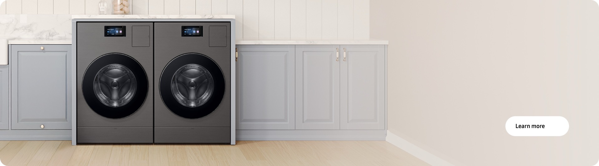 Two washer dryer combos side-by-side in laundry room