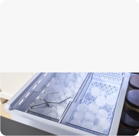Close up of two internal ice trays with graphic overlay of Cubed Ice and Sphere Ice icons and labels