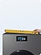 Hand holds a yellow level at an angle on top of Bespoke AI Laundry Combo™ in Dark Steel