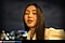 A photo of a woman outdoors at night with a lit face and blurred city lights in the background. Text reads Captured by Galaxy S24 FE #withGalaxy.