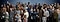 Several people of different ages, genders and ethnicities are standing or sitting together and smiling.