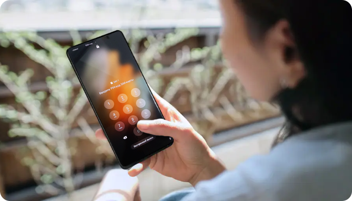 Человек со смартфоном Samsung Galaxy, на котором установлена блокировка SIM-карты