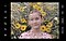 The screen of a Galaxy S21 Ultra 5G showing a portrait of a girl in front of yellow flowers taken through droplets of water. The water droplets are highlighted by a circular symbol, indicating they should be in focus.
