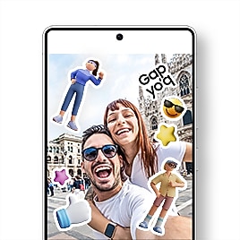 В центре экрана Galaxy S25 Ultra отображается приложение «Галерея» с селфи весёлой пары — мужчины и женщины — в месте их путешествия. Фотография украшена милыми стикерами, среди которых молодой мужчина, уверенная в себе женщина в спортивной одежде, трёхмерная белая рука с поднятым вверх большим пальцем и синим рукавом, трёхмерные розовые и жёлтые звёзды, жёлтый смайлик с солнцезащитными очками и текстовый стикер «Без кепки».