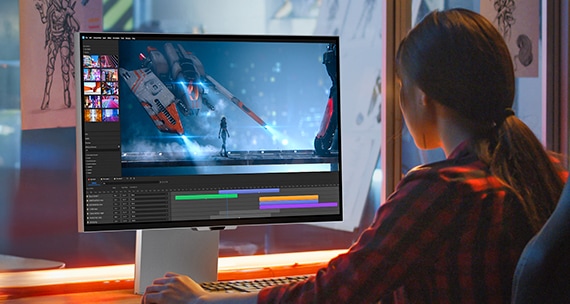 Một người phụ nữ đang chỉnh sửa video trên màn hình.