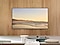 Installed on the wall of a living room, The Frame displays a peaceful scene of a seashore.