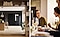 A triple door black Samsung Bespoke fridge in a kitchen. Two women laughing at a dinner party whilst eating food.