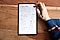 An overhead shot of a black Galaxy Tab S6 Lite that shows a weekly spread of plans, habit trackers, a motivational quote that says "Believe in Yourself" and a list of readings for the week on the Samsung Notes app. There is a range of pen/pencil options at the top left corner with a range of colour options on the top right corner, which Amanda is navigating with her finger as she holds an S Pen.