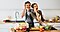 Young couple holding sliced bell pepper in front of their eyes and having fun as they're cooking in the kitchen.