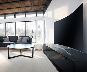 see large image of left perspective image of TV in a living room and round table is in front.