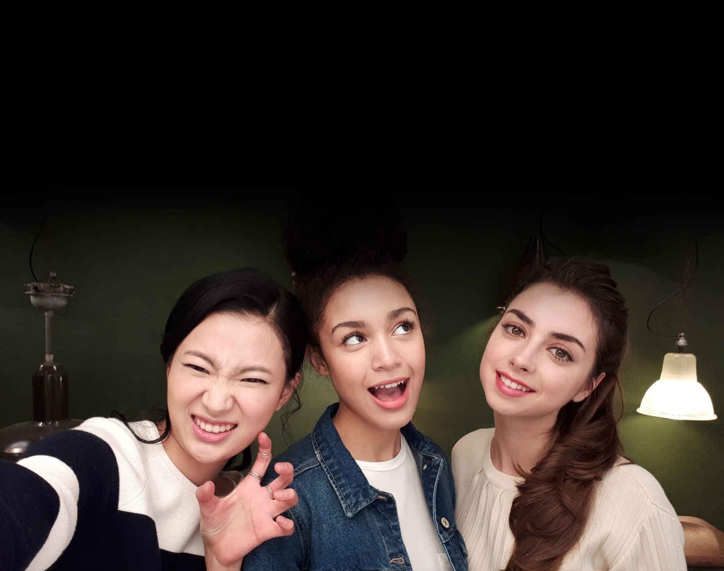 Selfie image of three women taken in low-light to show the advanced camera functionality of the Galaxy A7 (2017).