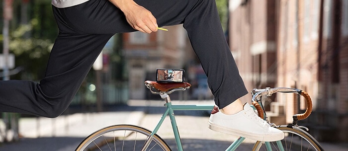 A Galaxy Note 9 rests on a seat while the rider is seen in mid air shooting a photo with the S Pen's remote control.