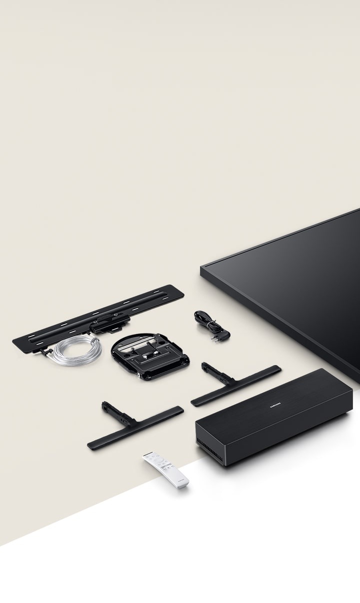 The Frame TV and its accessories are arranged on a flat, beige surface, including: monitor, Standard Stand, No Gap Wall-mount, Invisible Connection, power cable, One Connect Box, and One Remote Control.