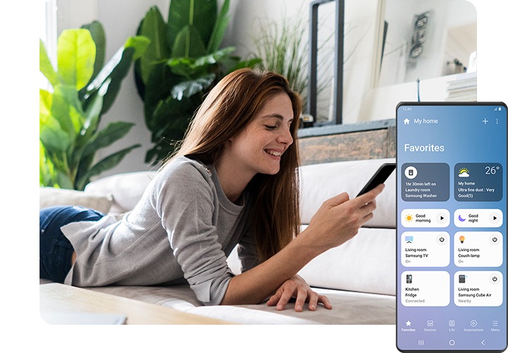 سيدة مستلقية على الأريكة تبتسم وهي تنظر إلى هاتفها الذكي. على الجانب الأيمن من المقدمة، تعرض شاشة Galaxy واجهة المستخدم الرسومية لتطبيق SmartThings يظهر بها العديد من الأجهزة المنزلية الذكية المتصلة، وحالاتها، وغيرها من الأنشطة الروتينية التي يمكن إعدادها، بما في ذلك "Good morning" (صباح الخير) و"Good night" (تصبح على خير).