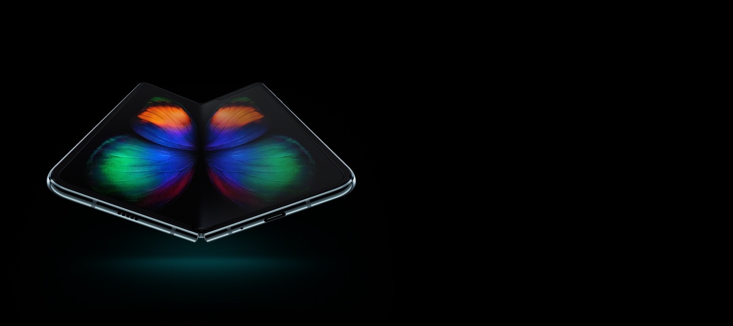 Galaxy Fold باللون الفضي، غير مطوي ومرئي بزاوية بسيطة من الأسفل، ومعروض على شاشته رسم فراشة متعددة الألوان.