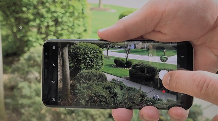Click to play a video with reviews An Image holding Galaxy S8 Midnight Black on the right hand with running camera.