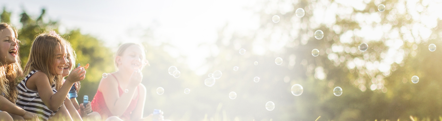Enfants crevant des bulles avec un sourire.