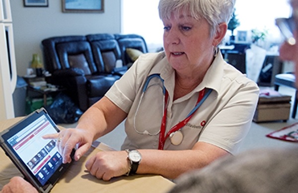 Une image montrant une infirmière qui explique des notions à un patient, à l’aide des supports présentés sur l’écran de la tablette. Si vous cliquez sur l’image, vous pouvez naviguer vers la page présentant plus en détail Saint Elizabeth.
