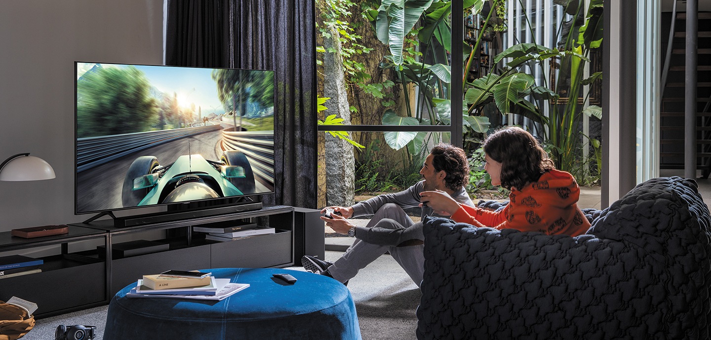Un homme et une femme jouent à un jeu sur le téléviseur intelligent Samsung.