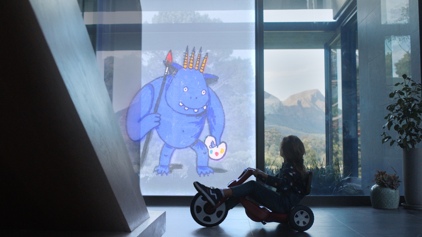 Enfant sur un tricycle regardant l’image d’une créature sur une fenêtre transparente d’un bâtiment