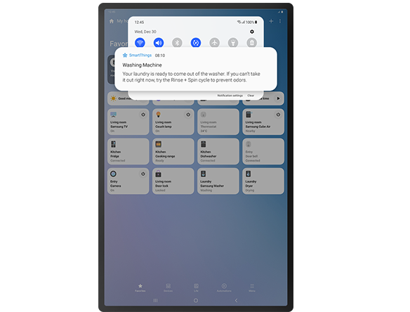O ecrã do tablet mostra a GUI da SmartThings com uma notificação de que a lavagem da roupa terminou e com opções para definir ambientes automatizados.
