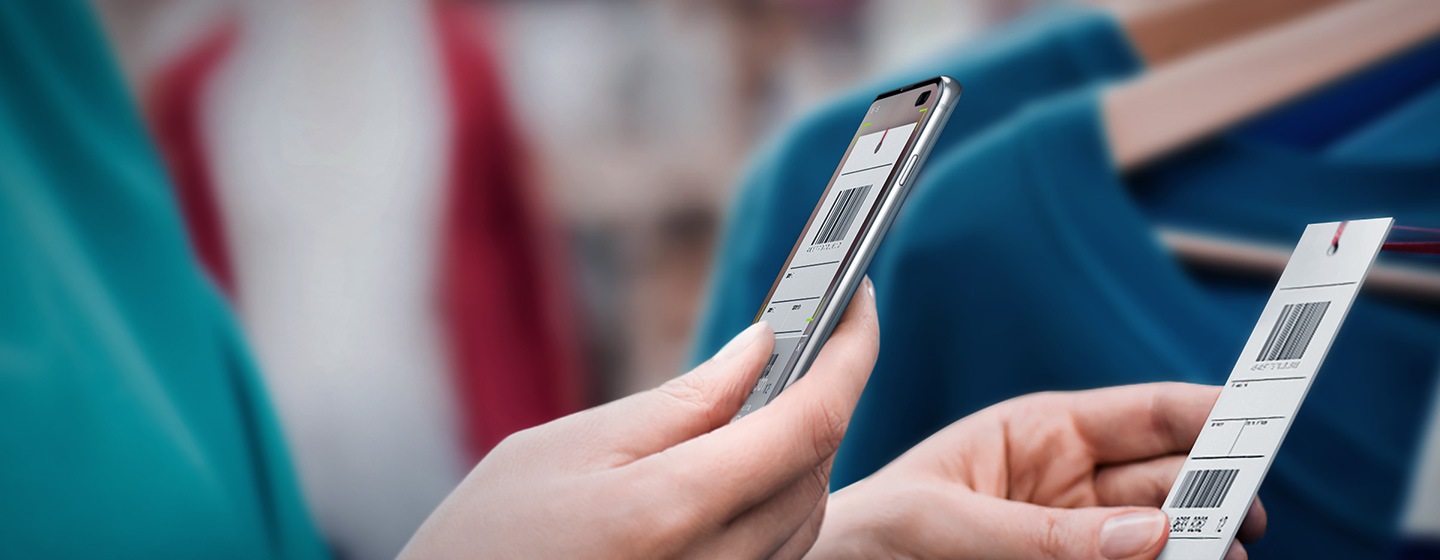 Imagem de um trabalhador de retalho a usar o Galaxy S10 plus para digitalizar um código de barras.