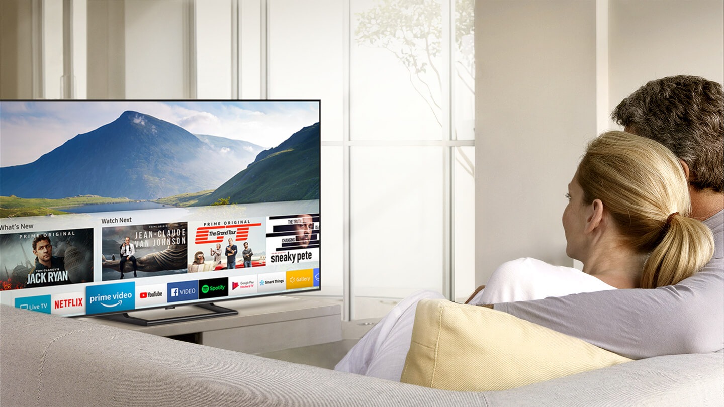 2 pessoas estão a ver a Smart TV; a aplicação do Prime Video recomenda filmes.