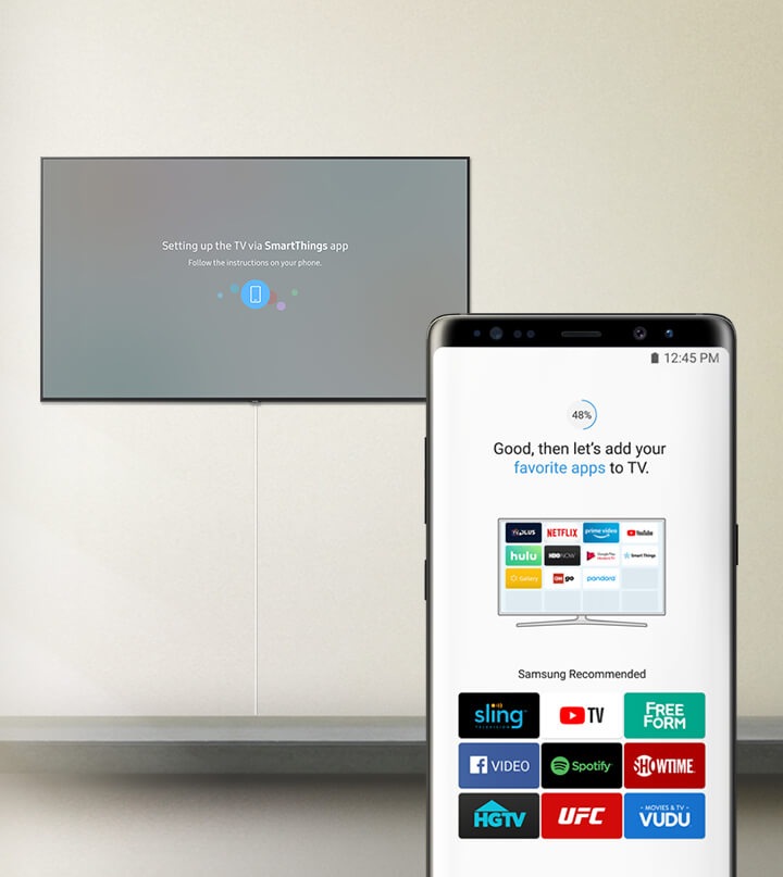 Legenda na TV "Configurar a TV via aplicação SmartThing", legenda no telemóvel "Bom, então vamos adicionar as suas aplicações favoritas à TV." com aplicações recomendadas pela Samsung; STEAM LINK, vimeo, internet, tunein, DEEZER, Berliner Philharmoniker.