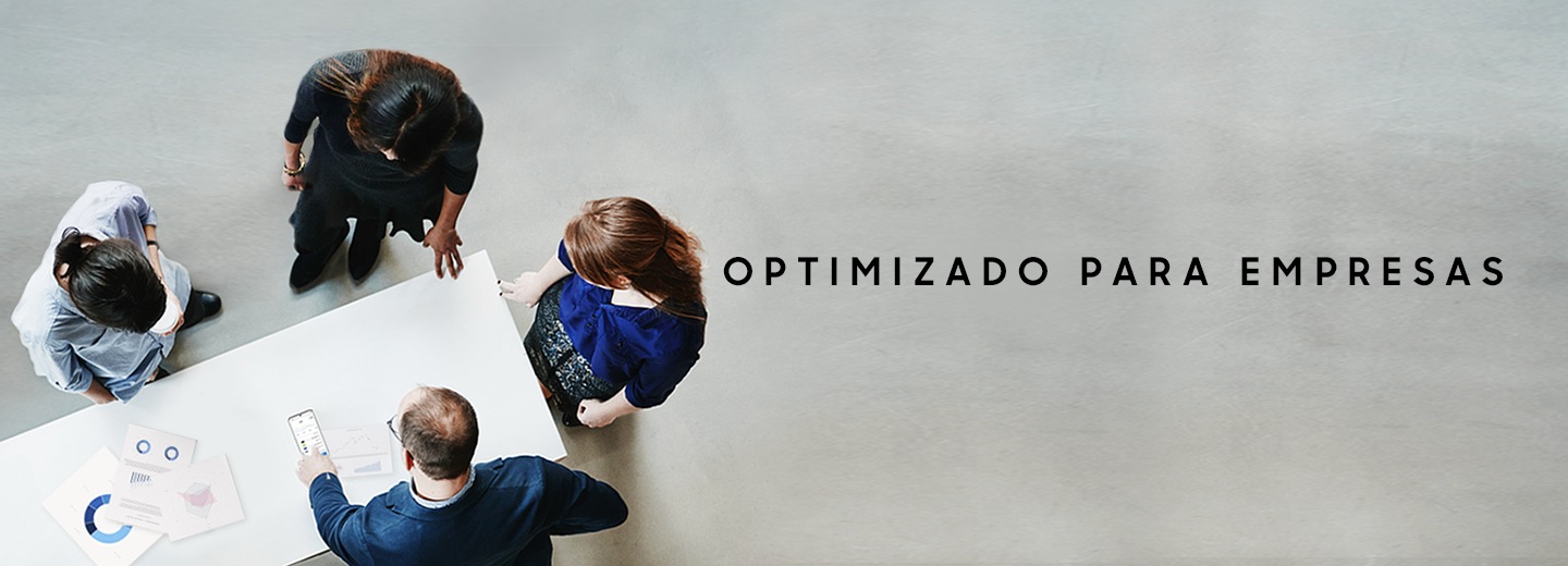 Cuatro personas paradas alrededor de una mesa con tablas encima. Un hombre apunta hacia la pantalla del Galaxy S20 Ultra y la pantalla incluye el texto: “Optimized for Business” (Optimizado para negocios)