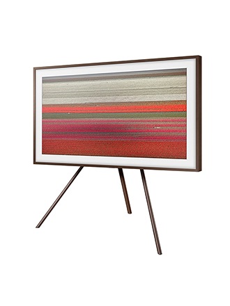 Televisor The Frame de Samsung con biseles de nogal personalizables sobre el soporte Studio