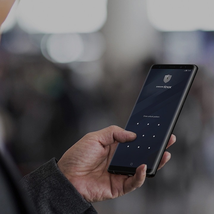 Ein Mann, der auf sein Samsung Smartphone tippt, dessen Bildschirm mit der Samsung Knox-Lösung gesichert ist