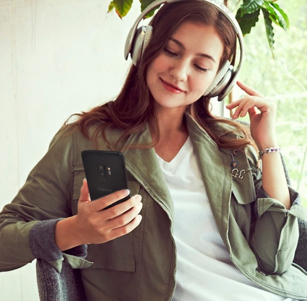 Frau die über ihr Level Over Musik von ihrem Samsung Galaxy S9 hört