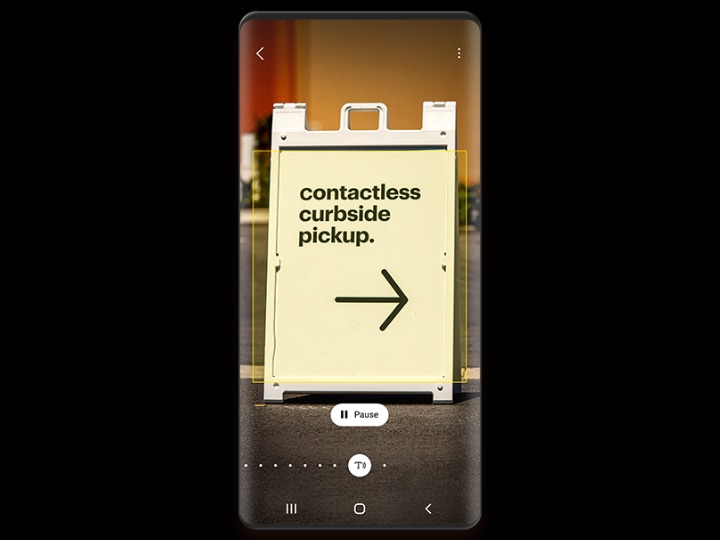 A phone screen shows an A-frame sign with the text "contactless curbside pickup", identified by Bixby Vision, and a pause button below the image.