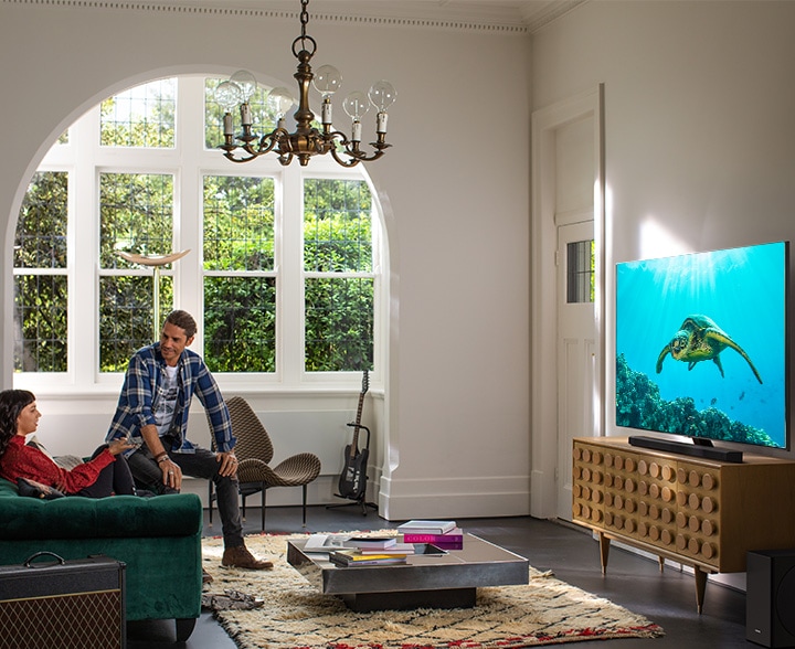 A couple enjoying moment in living area and looking at Samsung tv