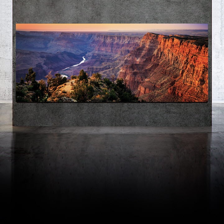 Samsung The Wall mounted on a large concrete wall with a grand view of a cliff at sunset
