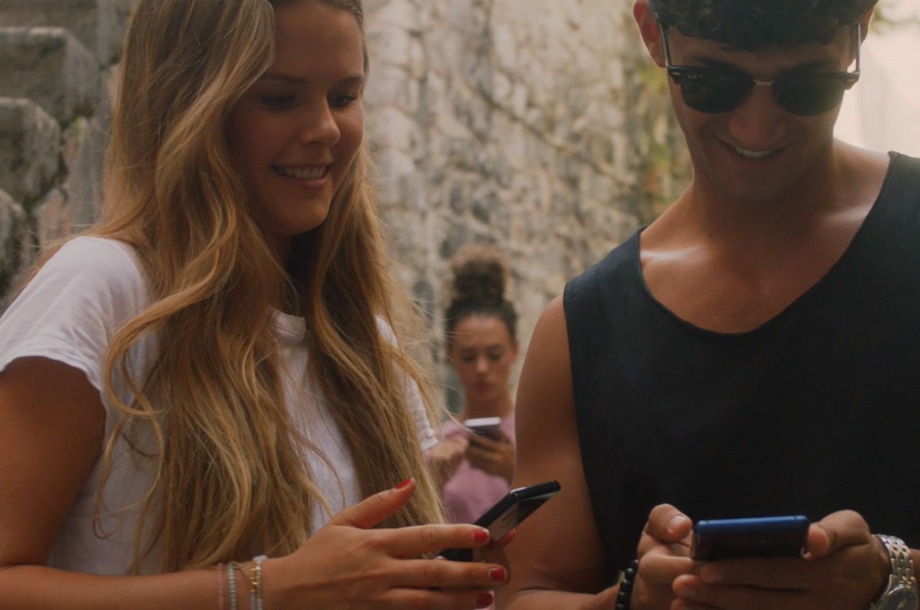 Une femme et un homme regardent leur téléphone respectif en souriant