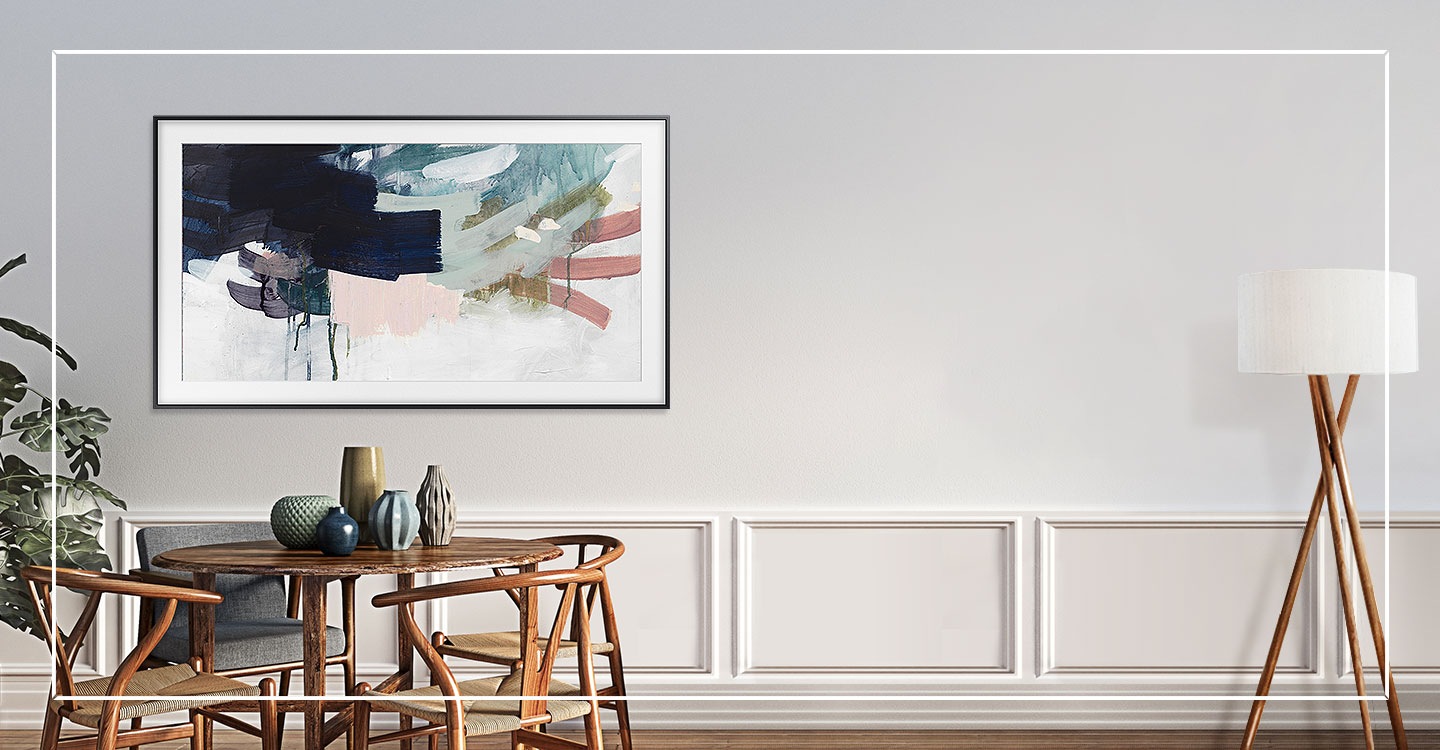Une femme passe devant la TV The Frame 2020 de Samsung fixée au mur qui ressemble à une œuvre d'art alors que l'image à l'écran est une peinture disponible en Art Mode.