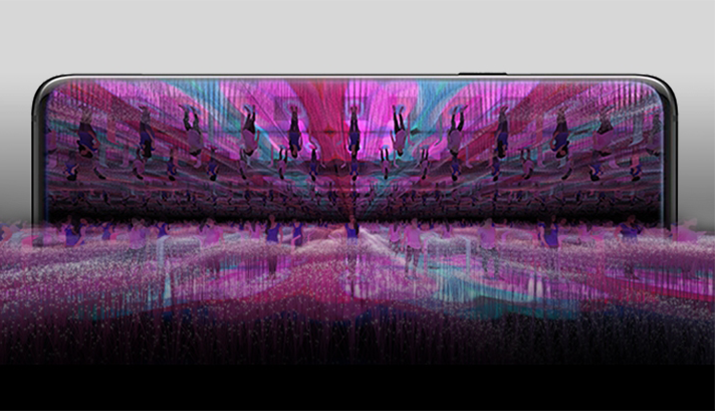 Na imagem aparece a Tela do Galaxy S10 apresentando uma pessoa em pé na sala de espelho que está cheia de displays visuais coloridos
