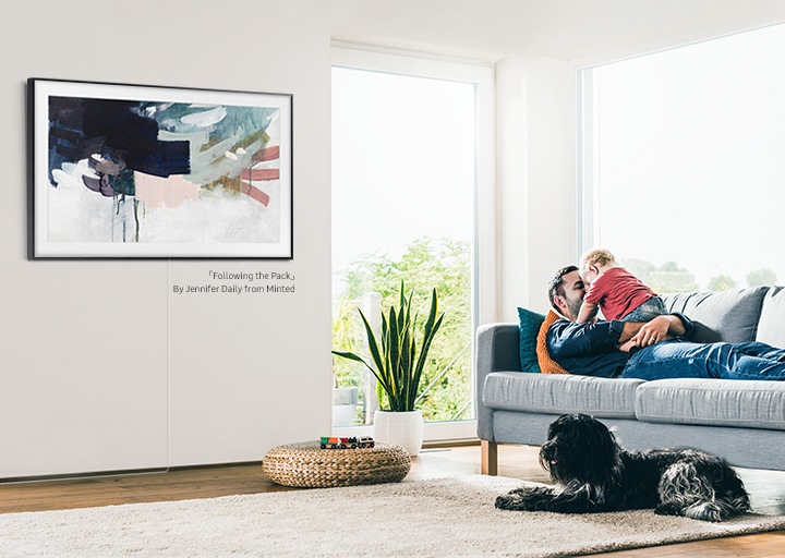 A TV The Frame 2020, com uma moldura criada para parecer um quadro de verdade que combina com a sala de estar. A TV mostra a obra “Following the Pack” por Jennifer Daily.